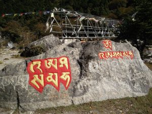 Rot-goldene Sanskrit-Zeichen auf Fels in Nepal (Im Sherpa Culture Museum – Trek zurück nach Namche Bazar)