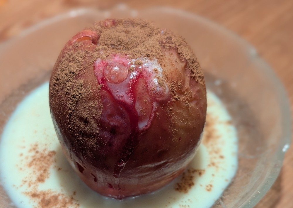 Bratapfel mit Marzipan in veganer Vanillesoße mit Zimt bestreut am Weltbratapfeltag 2025 Bratapfel mit Marzipan in veganer Vanillesoße mit Zimt bestreut am Weltbratapfeltag 2025